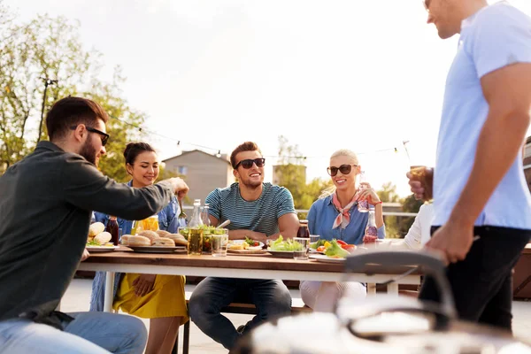 Amis heureux manger et boire à la fête sur le toit — Photo