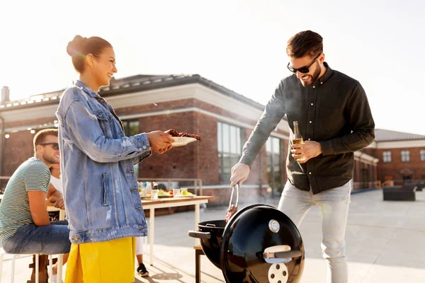 Amigos cocinar carne en la barbacoa en la fiesta en la azotea — Foto de Stock