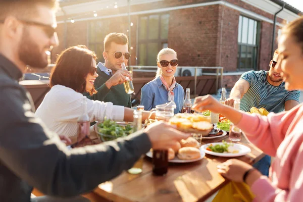 Freunde beim Abendessen oder bei einer Grillparty auf dem Dach — Stockfoto