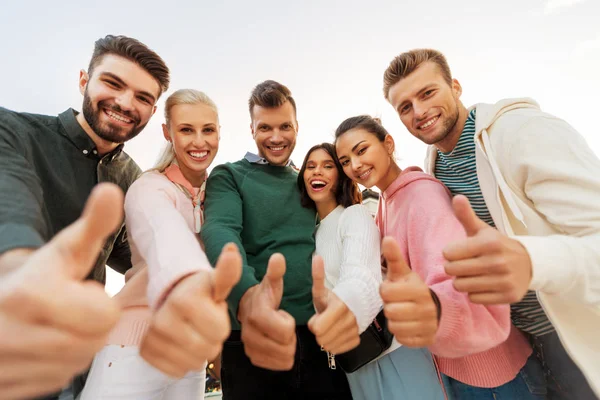 Amici felici mostrando pollici in su — Foto Stock