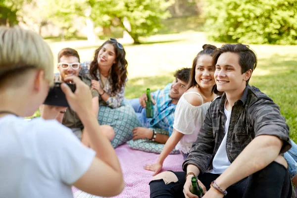 Amigos con bebidas fotografiando en el picnic de verano —  Fotos de Stock