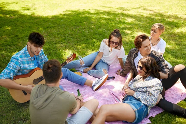 Amigos tocando la guitarra en el picnic en el parque de verano —  Fotos de Stock
