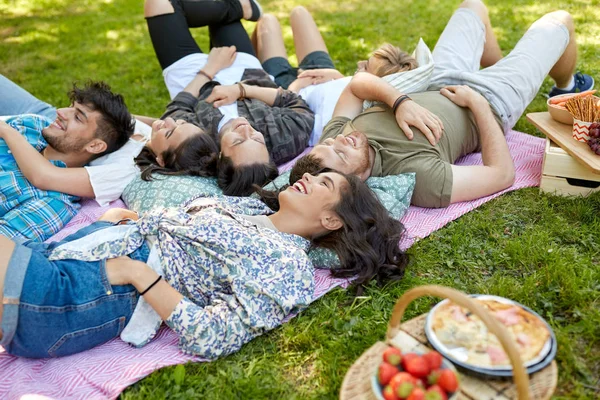 Happy vrienden op picknick deken koelen in de zomer — Stockfoto