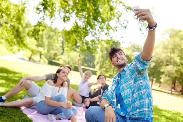 Amigos tomando selfie por teléfono inteligente en el picnic — Foto de Stock