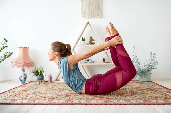 Jonge vrouw doen boog pose in yoga studio — Stockfoto