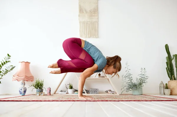 Ung kvinna som gör kran poserar på yogastudion — Stockfoto