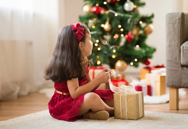 Девочка с рождественским подарком дома — стоковое фото