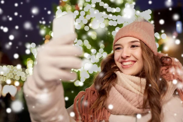 Jonge vrouw nemen selfie over kerstboom — Stockfoto