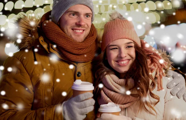 Gelukkige paar met koffie over Kerstverlichting — Stockfoto