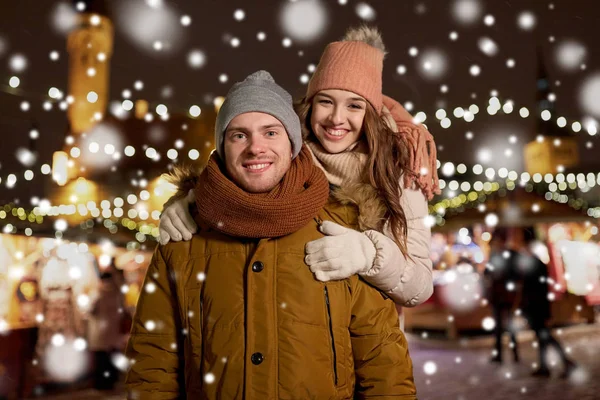 Glückliches Paar umarmt sich auf Weihnachtsmarkt — Stockfoto