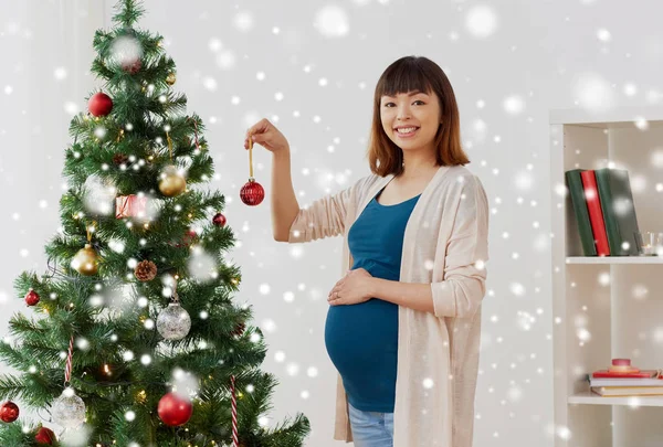Otthon a karácsonyfa díszítő terhes nő — Stock Fotó