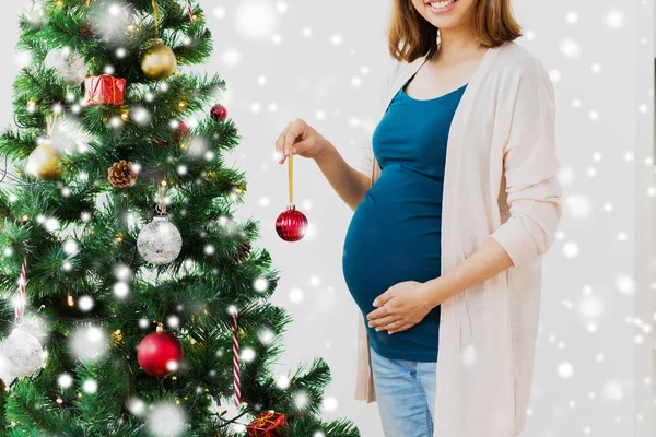 Mulher grávida decorando árvore de Natal — Fotografia de Stock