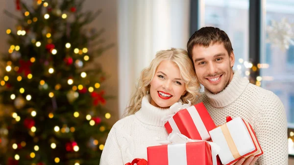 Casal feliz com presentes de Natal em casa — Fotografia de Stock