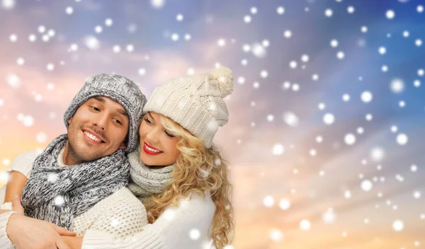 Sorrindo casal em camisolas sobre fundo de neve — Fotografia de Stock