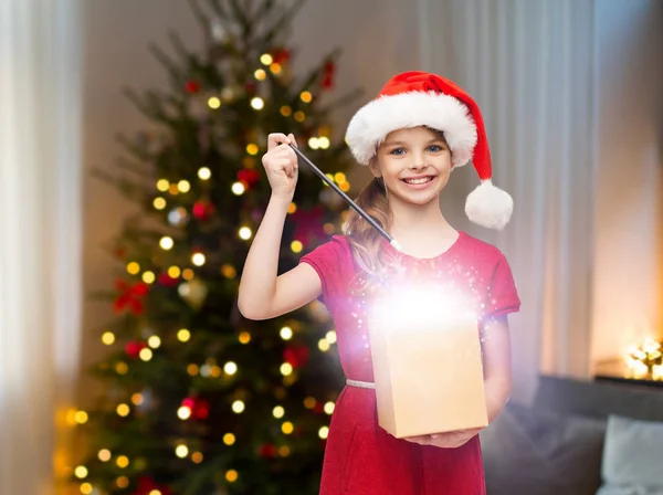 Glimlachend meisje met kerst cadeau en magische toverstaf — Stockfoto