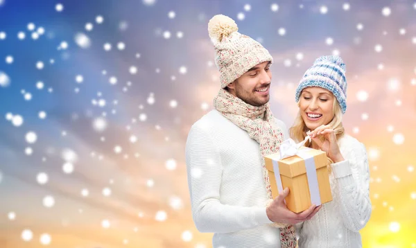 Casal sorridente em roupas de inverno com caixa de presente — Fotografia de Stock