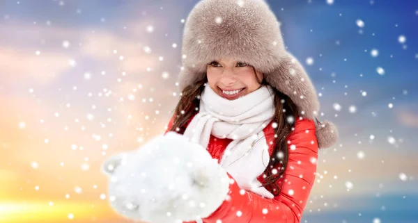 Happy woman with snow in winter fur hat outdoors — Stock Photo, Image