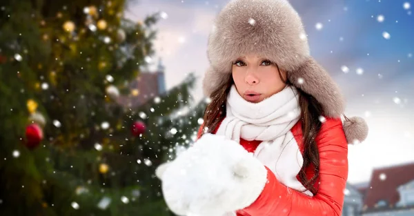 在圣诞树上吹雪的女人 — 图库照片
