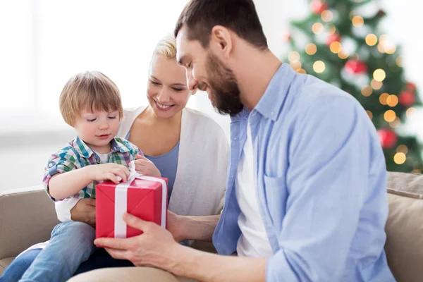 Família feliz com presente de Natal em casa — Fotografia de Stock