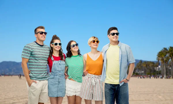 Happy friends in sunglasses over venice beach — Stock Photo, Image