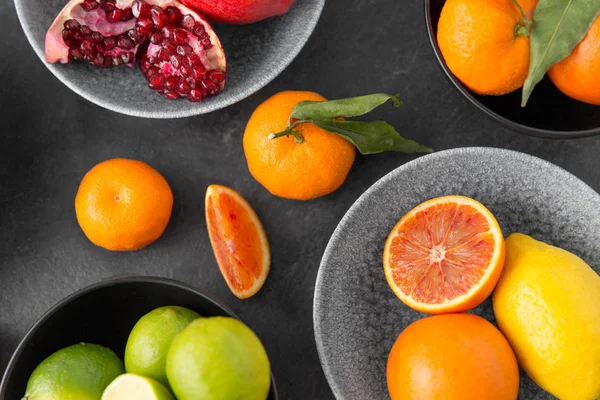 Närbild av citrus i skålar frukter på stenbord — Stockfoto