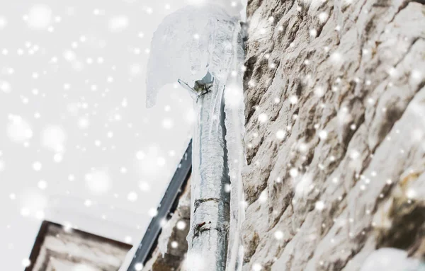 Icicles hanging from building drainpipe — Stock Photo, Image