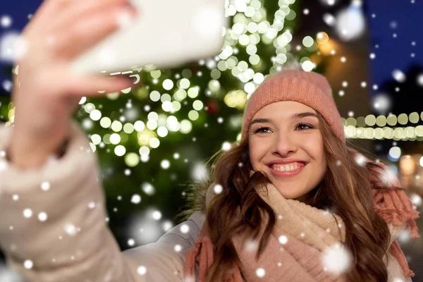 Jonge vrouw nemen selfie over kerstboom — Stockfoto