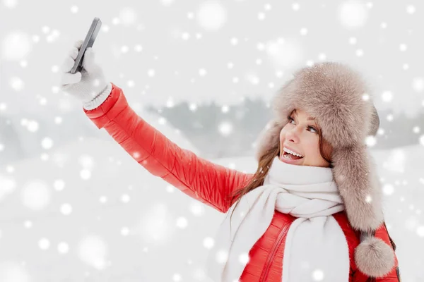 Gelukkige vrouw die selfie buiten in de winter — Stockfoto