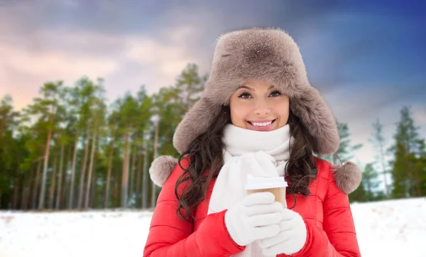 Γυναίκα με γούνινο καπέλο με καφέ πάνω από το δάσος του χειμώνα — Φωτογραφία Αρχείου
