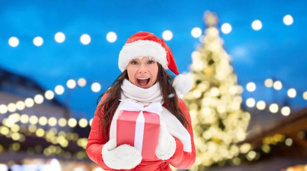 Mujer feliz con el regalo sobre el árbol de Navidad — Foto de Stock