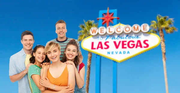Happy friends over las vegas sign background — Stock Photo, Image