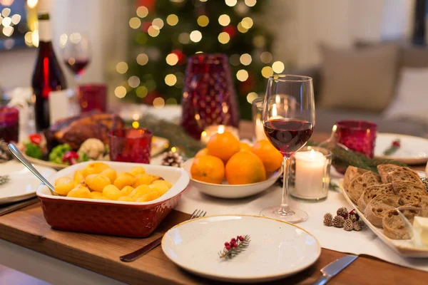 Sklenice červeného vína a jídla na vánoční stolek — Stock fotografie