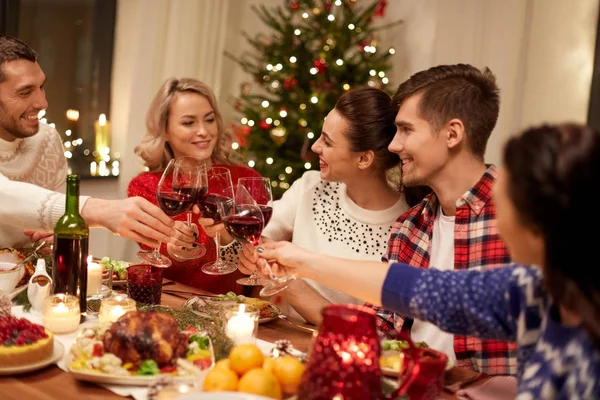 Ystävät juhlivat joulua ja juovat viiniä — kuvapankkivalokuva