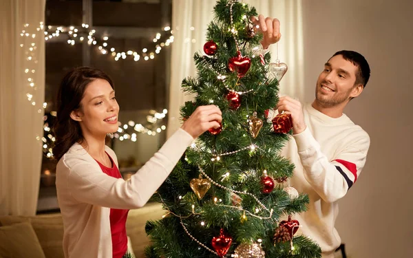 Ευτυχισμένο ζευγάρι διακόσμηση χριστουγεννιάτικο δέντρο στο σπίτι — Φωτογραφία Αρχείου