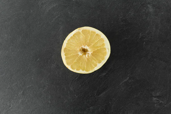 Primer plano de rodaja de limón en la mesa de pizarra —  Fotos de Stock