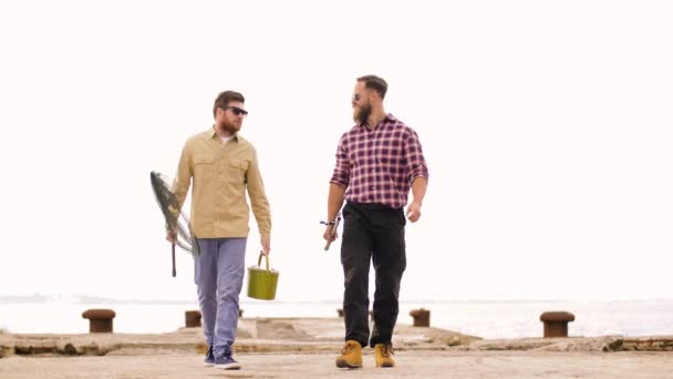 愉快的朋友与钓鱼竿沿着码头散步 — 图库视频影像