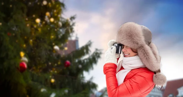 Vrouw met camera over kerstboom in tallinn — Stockfoto