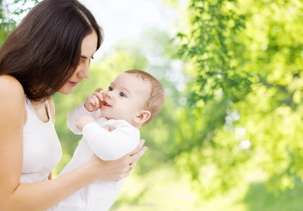 Mãe com bebê sobre fundo natural verde — Fotografia de Stock