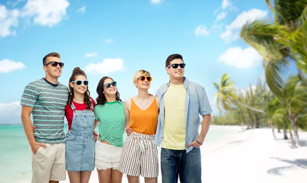 Vänner i solglasögon över exotisk strand bakgrund — Stockfoto
