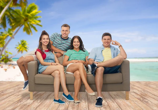 Přátele, jak sedí na pohovce nad tropickou pláž — Stock fotografie