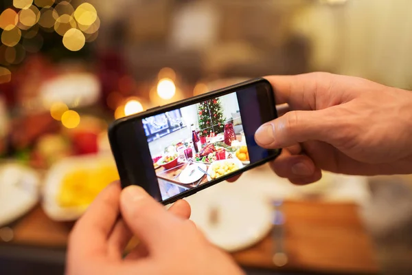 Noel yemeğinde yemek fotoğraflayan eller. — Stok fotoğraf
