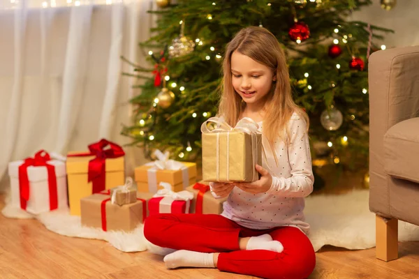 Menina sorridente com presente de Natal em casa — Fotografia de Stock