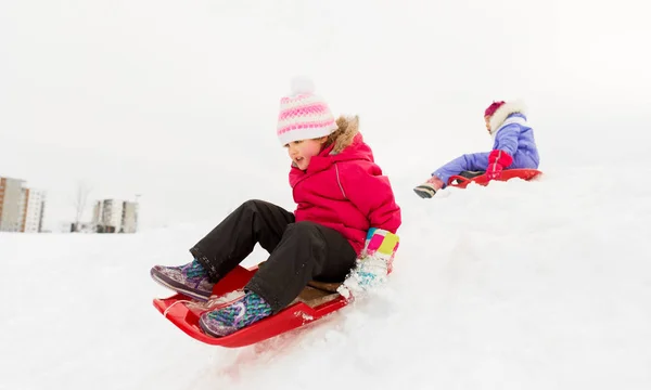 Menina feliz deslizando para baixo no trenó no inverno — Fotografia de Stock