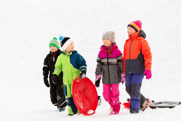 Gelukkig weinig kinderen met sleeën in de winter — Stockfoto