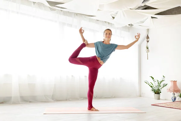 Genç kadının stüdyosu yoga tek bacaklı poz yapması — Stok fotoğraf