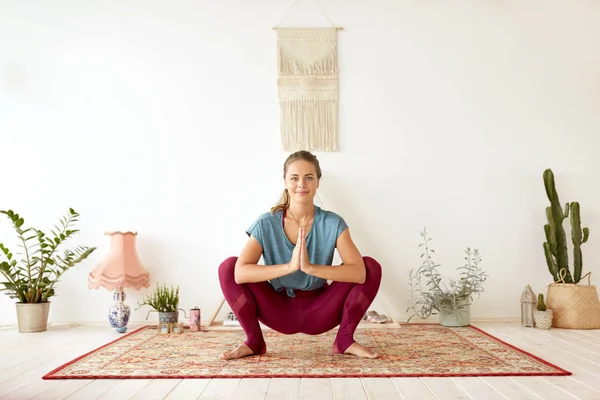 Mladá žena dělá věnce pózovat v jóga studiu — Stock fotografie