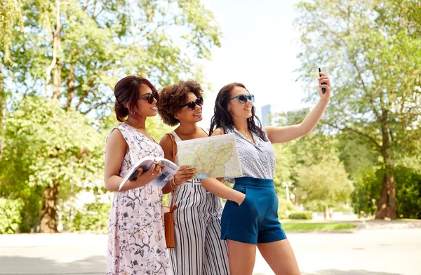 Mujeres con guía de la ciudad y mapa tomando selfie —  Fotos de Stock