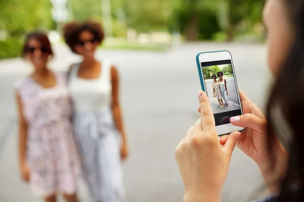 Woman photographing her friends in summer — Stock Photo, Image