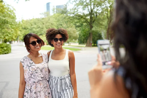 Mujer fotografiando a sus amigos en el parque de verano — Foto de Stock