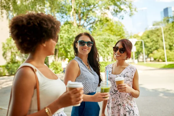 Счастливые женщины или друзья с напитками в летнем парке — стоковое фото